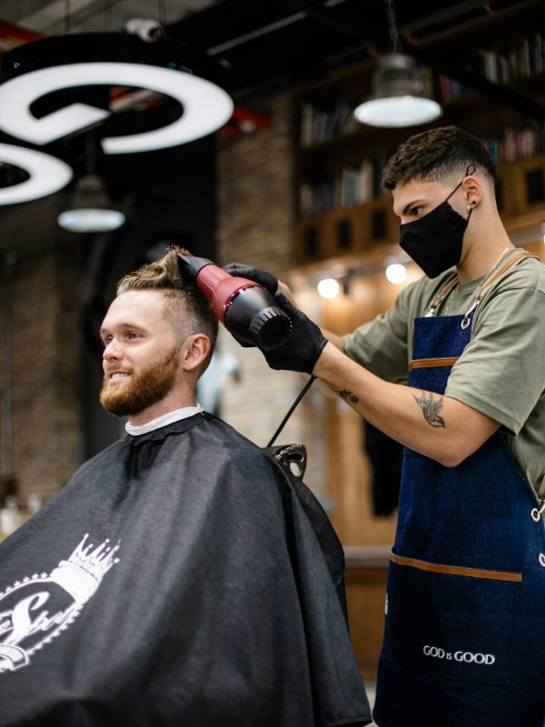 A barber styling a client in the chair